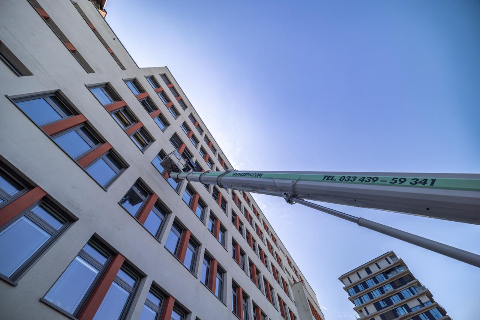 Zepik-Steiger-LKW mit ausgefahrenem Ausleger an einem Berliner Bürogebäude — Montage in großer Höhe